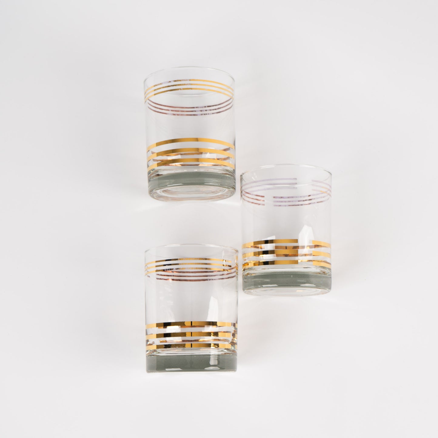 Set of three vintage lowball cocktail glasses with horizontal gold stripes 