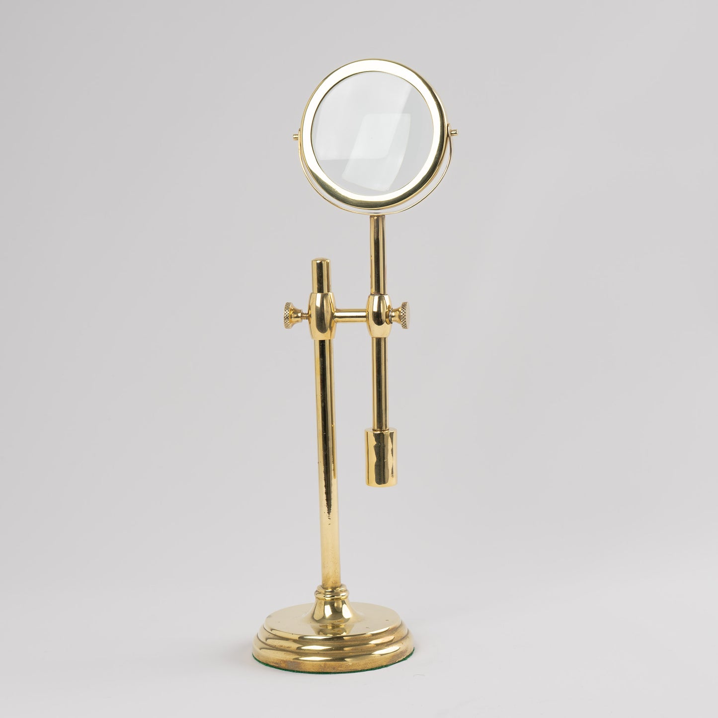 Vintage brass magnifying glass with adjustable stand by Sarreid, featuring brass finish and clear magnifying lens, marked Made in Korea