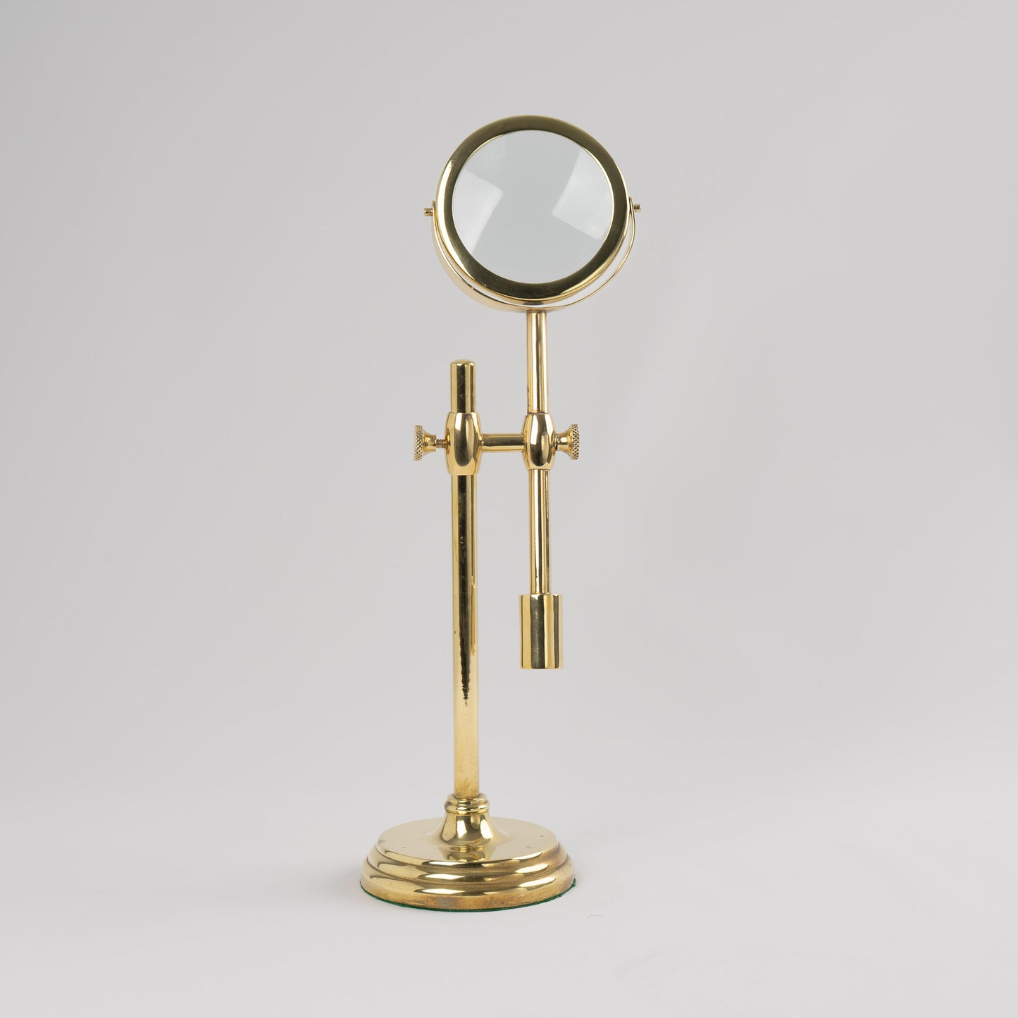 Vintage brass magnifying glass with adjustable stand by Sarreid, featuring brass finish and clear magnifying lens, marked Made in Korea