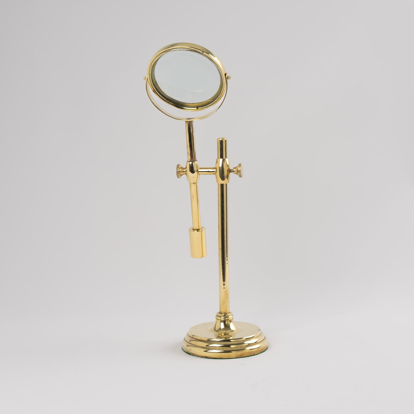Vintage brass magnifying glass with adjustable stand by Sarreid, featuring brass finish and clear magnifying lens, marked Made in Korea