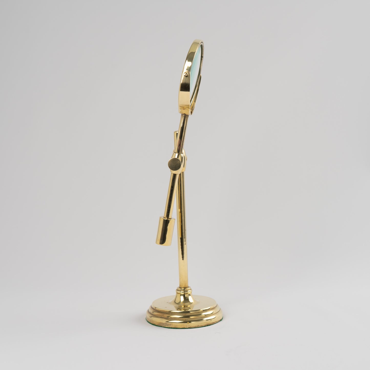 Vintage brass magnifying glass with adjustable stand by Sarreid, featuring brass finish and clear magnifying lens, marked Made in Korea