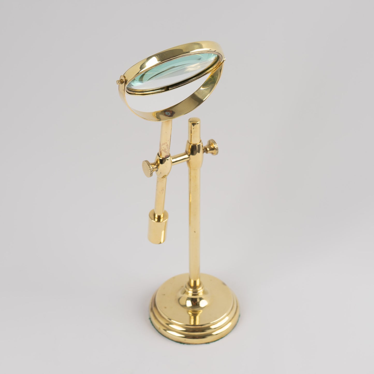 Vintage brass magnifying glass with adjustable stand by Sarreid, featuring brass finish and clear magnifying lens, marked Made in Korea