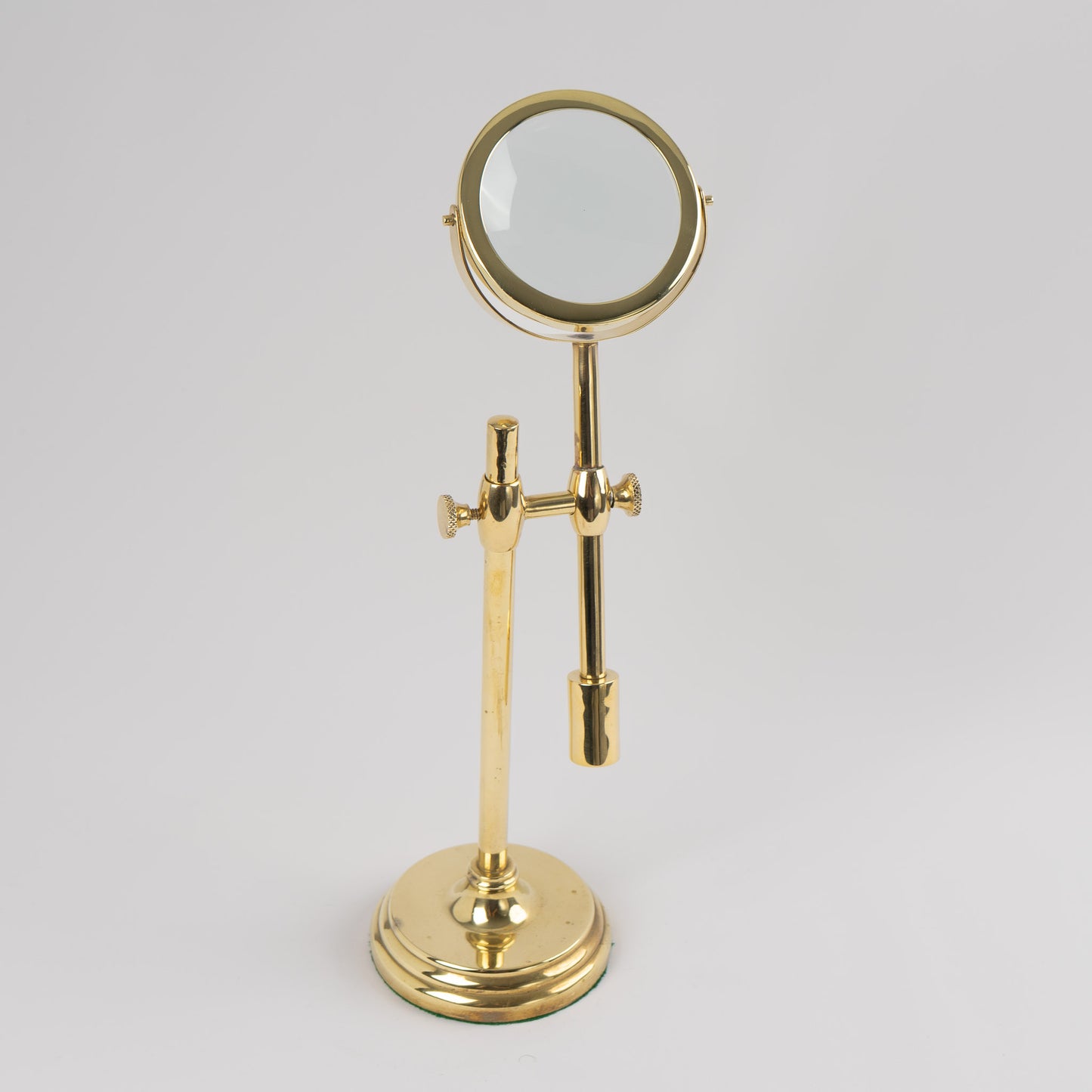 Vintage brass magnifying glass with adjustable stand by Sarreid, featuring brass finish and clear magnifying lens, marked Made in Korea