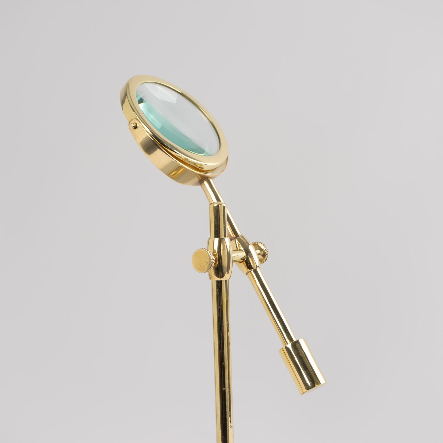 Vintage brass magnifying glass with adjustable stand by Sarreid, featuring brass finish and clear magnifying lens, marked Made in Korea