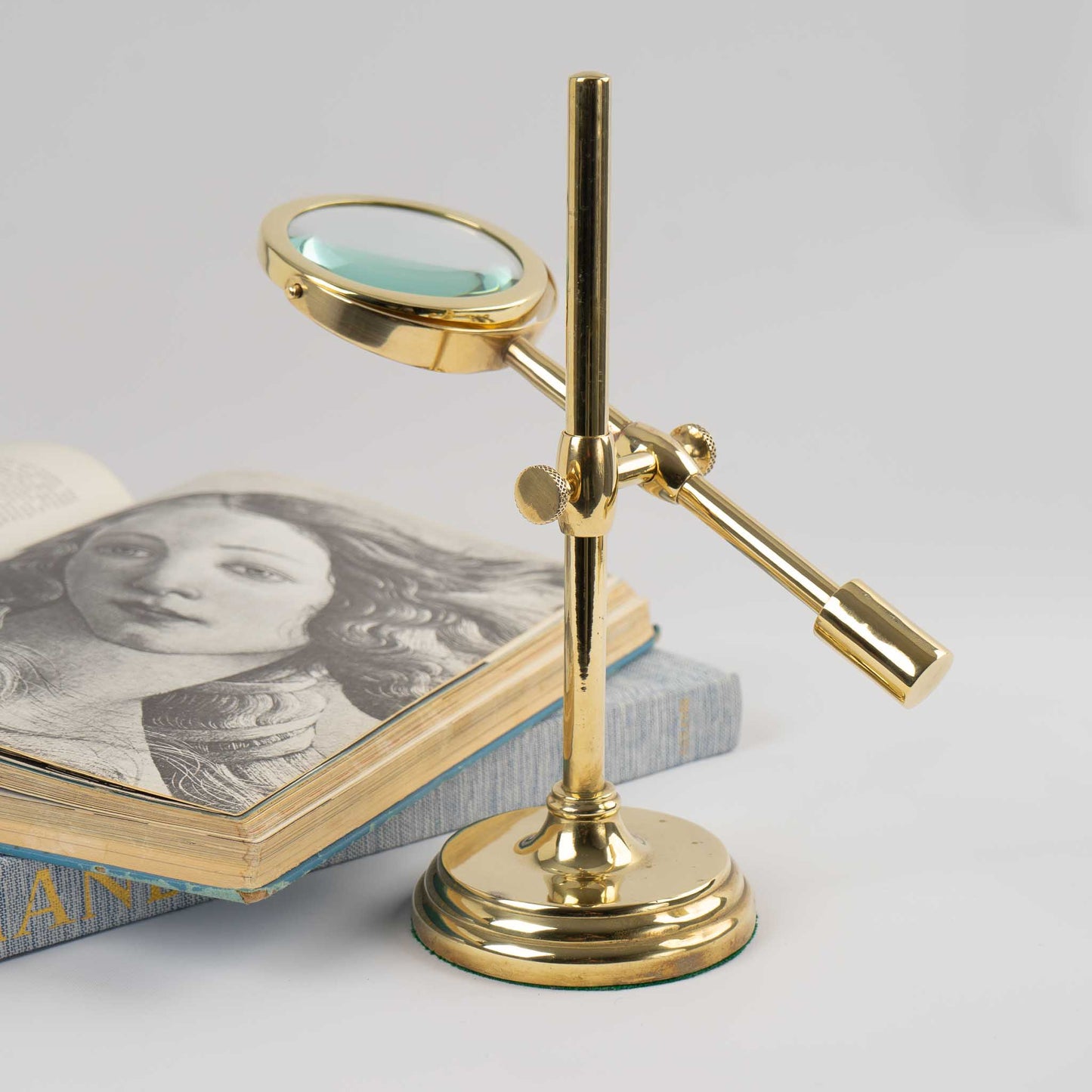 Vintage brass magnifying glass with adjustable stand by Sarreid, featuring brass finish and clear magnifying lens, marked Made in Korea