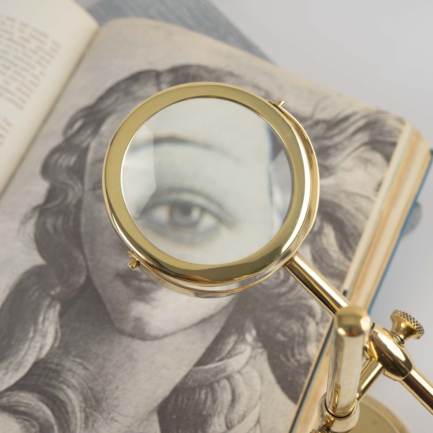 Vintage brass magnifying glass with adjustable stand by Sarreid, featuring brass finish and clear magnifying lens, marked Made in Korea