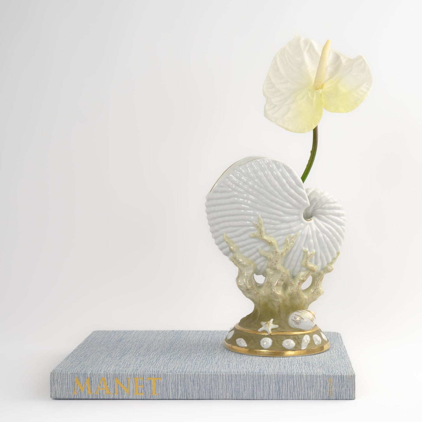 Vintage nautilus seashell-shaped porcelain vase with green coral and gold accents on off-white ceramic base in the style of Royal Worcester, England