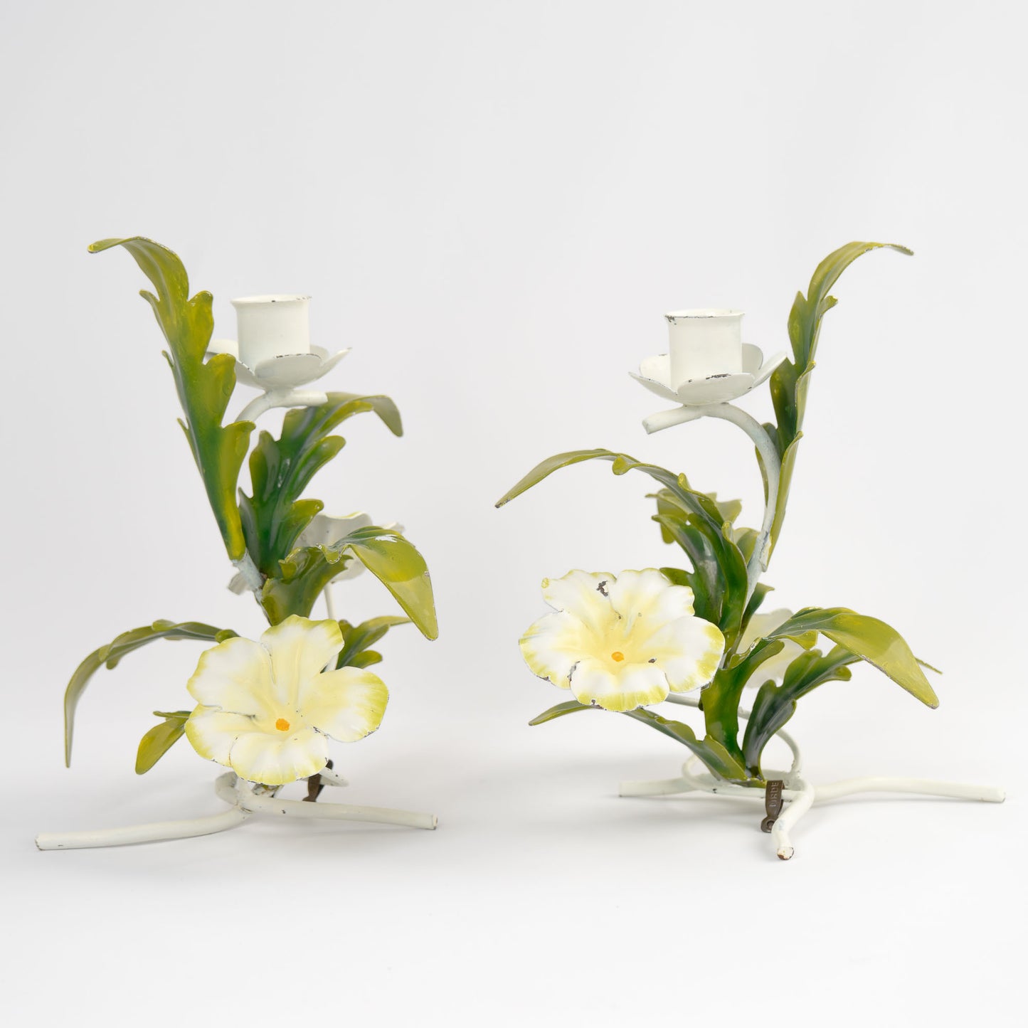 Vintage 1960s Italian tole metal candlestick holders with hand-painted white and yellow floral design and green leaves