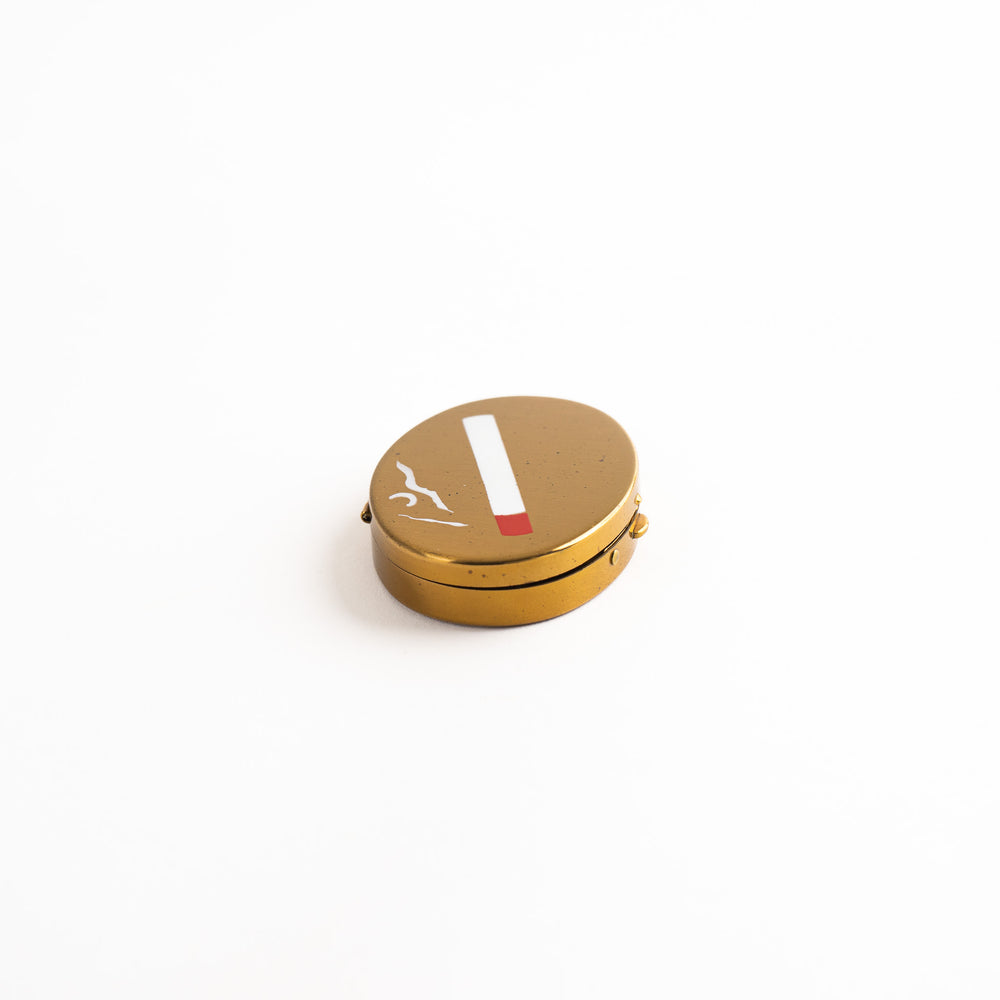 
                  
                    vintage oval brass pocket ashtray with painted cigarette design
                  
                