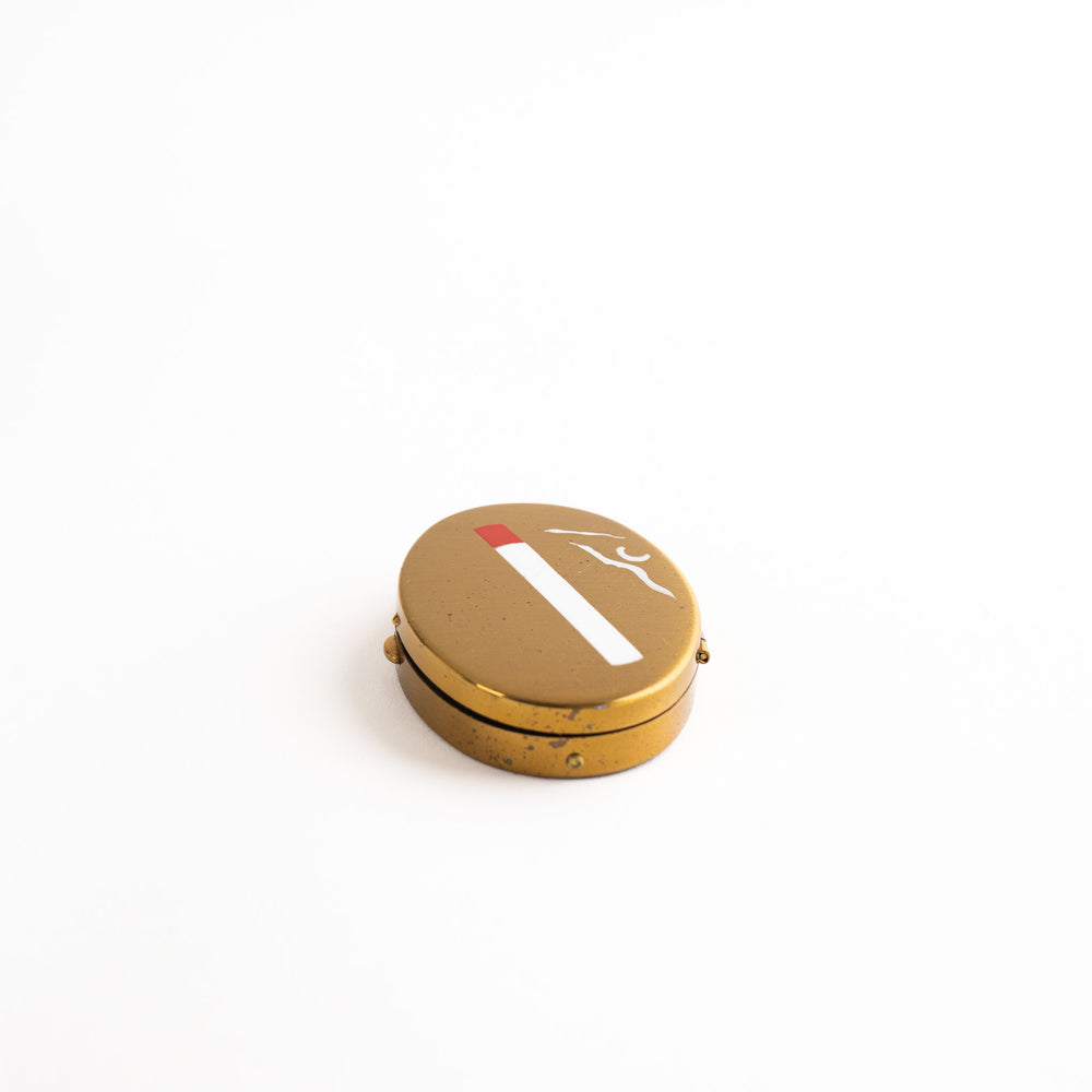 
                  
                    vintage oval brass pocket ashtray with painted cigarette design
                  
                