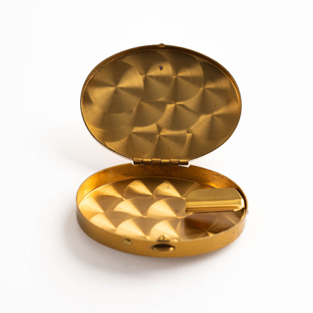 
                  
                    vintage oval brass pocket ashtray with painted cigarette design
                  
                