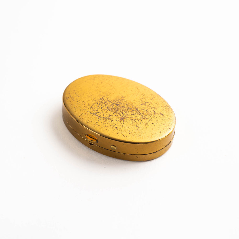 
                  
                    vintage oval brass pocket ashtray with painted cigarette design
                  
                