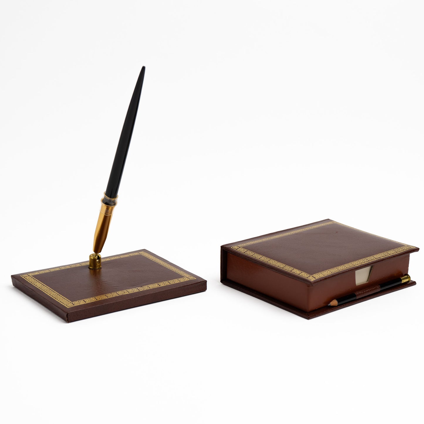 A dark brown leather desk set featuring a pen stand with a black pen and a matching closed note card box, both decorated with gold Greek key trim.