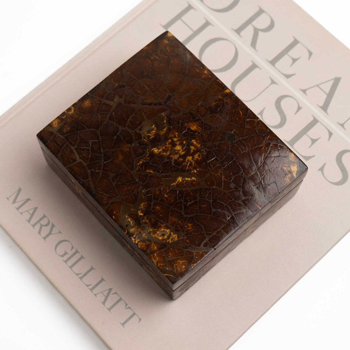 Tessellated coconut shell box styled as decor on a vintage coffee table book