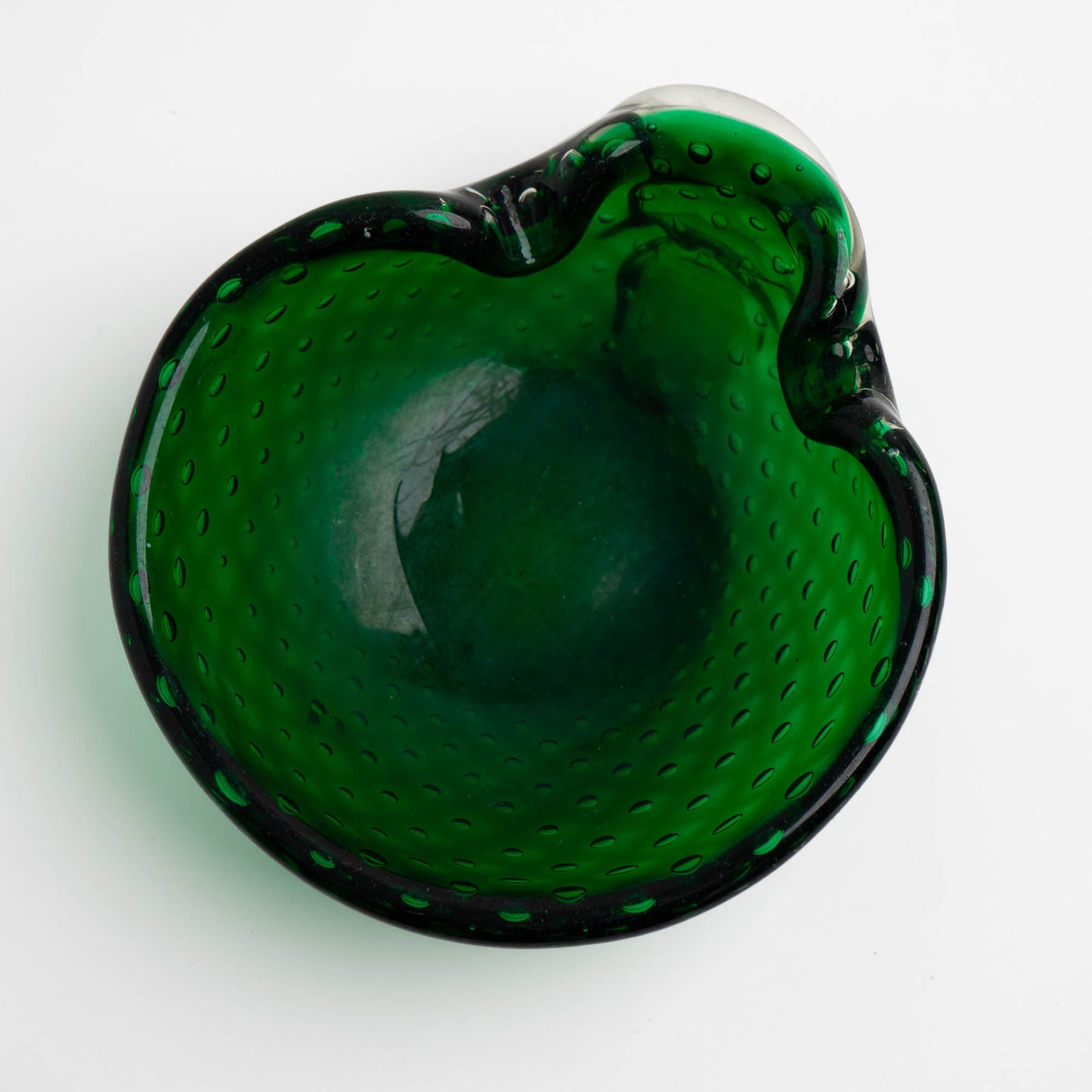 Close-up of green Murano glass dish showing symmetrical air bubble rows in thick glass