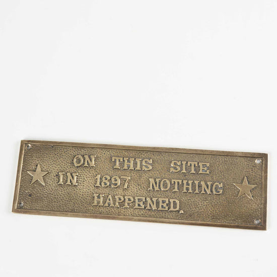 vintage brass rectangle plaque reading "On This Site in 1897 Nothing Happened"