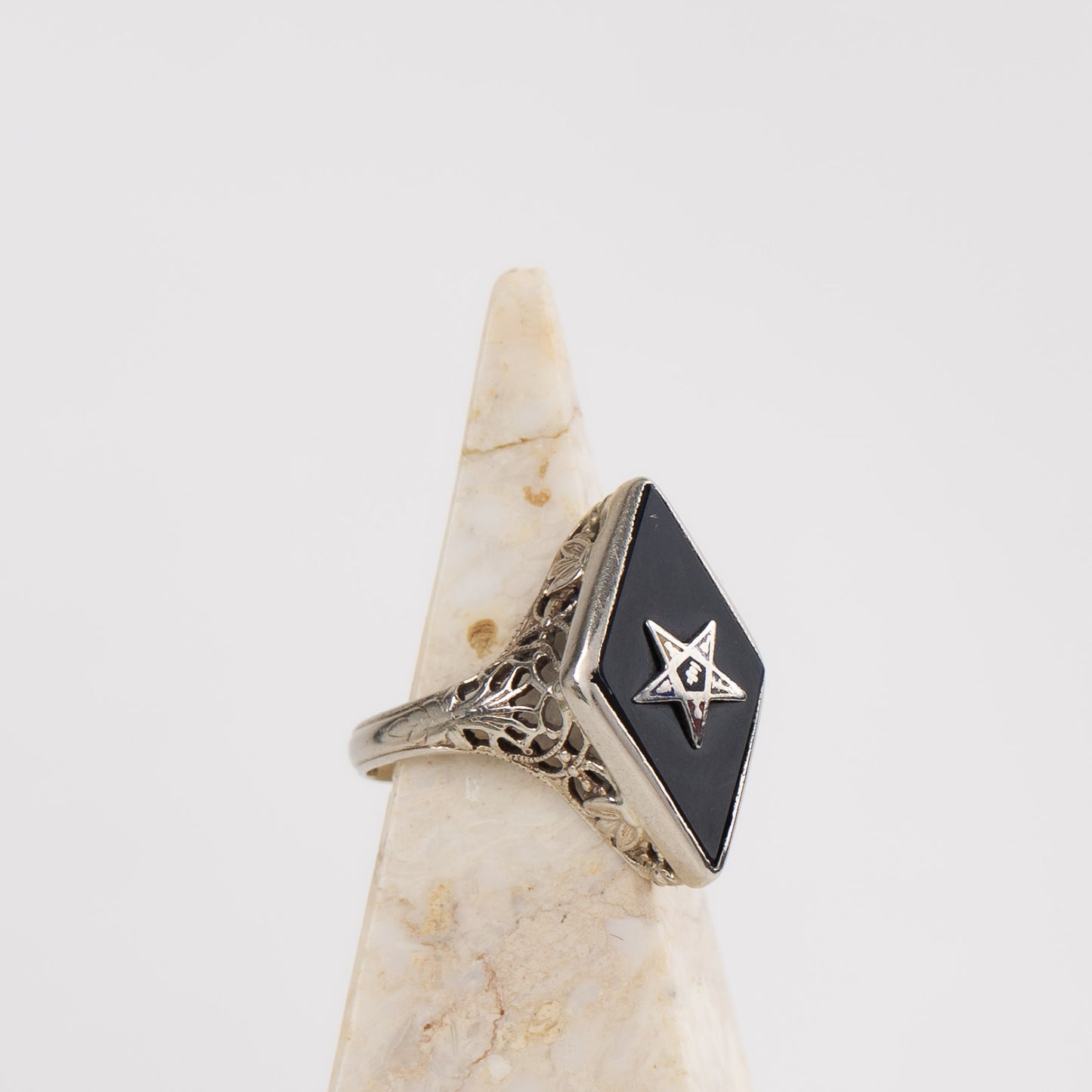 Vintage 14k white gold masonic ring with black onyx stone featuring Eastern Star symbol inlay, showing Art Nouveau decorative details on band sides