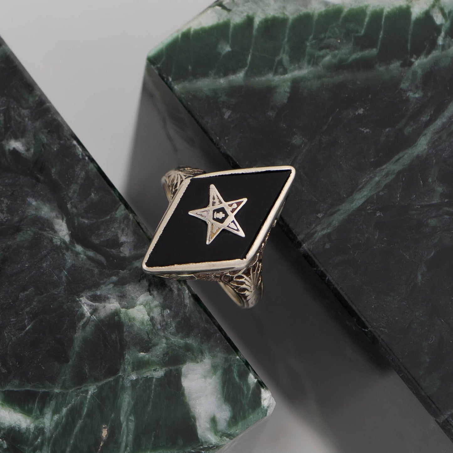 Vintage 14k white gold masonic ring with black onyx stone featuring Eastern Star symbol inlay, showing Art Nouveau decorative details on band sides
