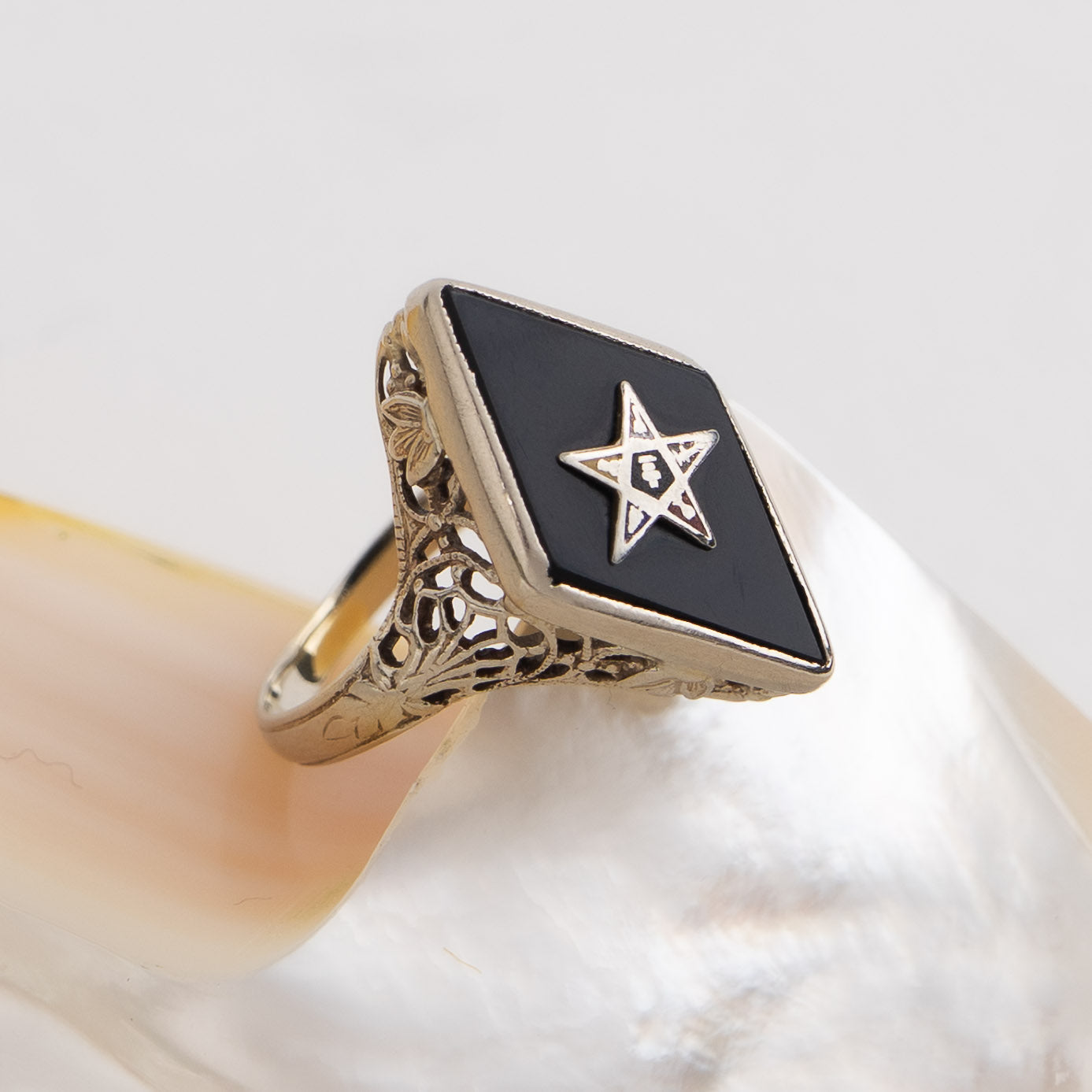 Vintage 14k white gold masonic ring with black onyx stone featuring Eastern Star symbol inlay, showing Art Nouveau decorative details on band sides