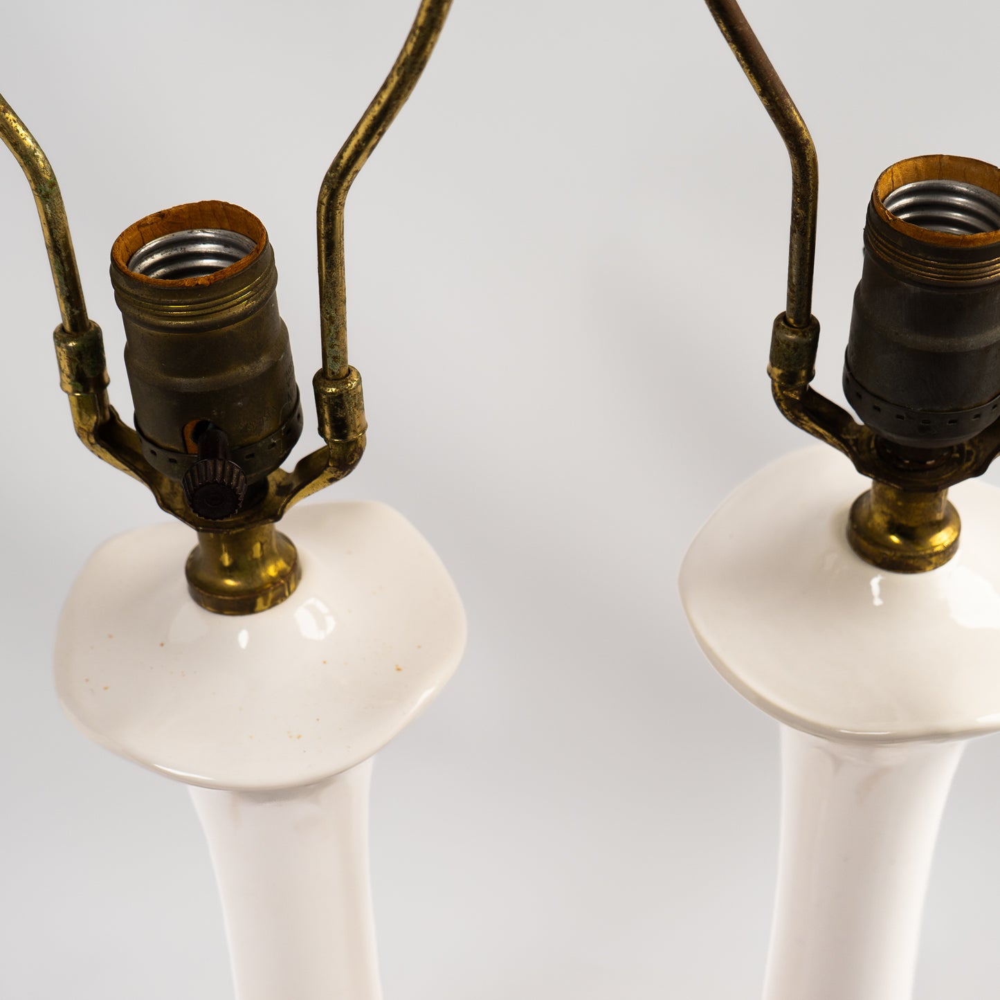 Pair of vintage mid-century off-white ceramic chinoiserie lamp bases with original harps and finials, circa 1950s–1960s.
