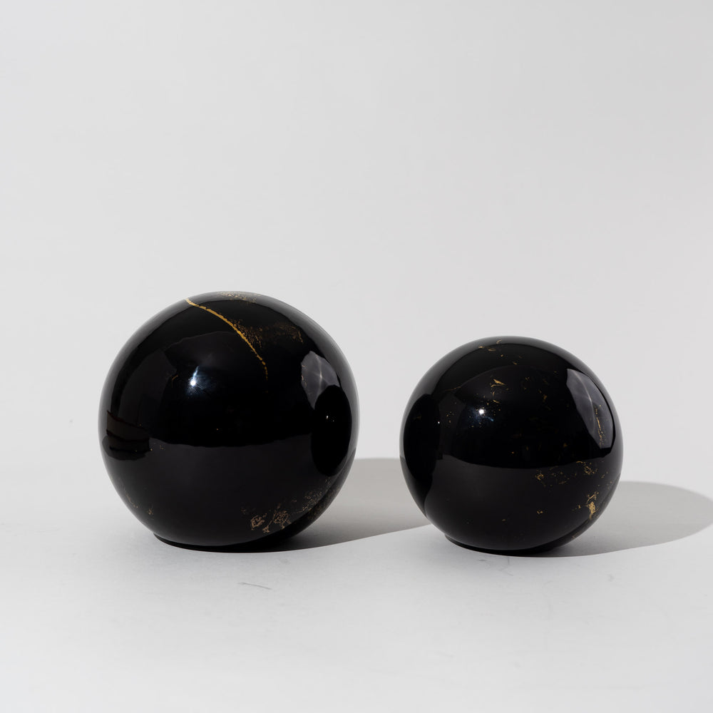 
                  
                    Pair of vintage black ceramic spheres with gold marbling, one large and one small, in the style of Sascha Brastoff
                  
                