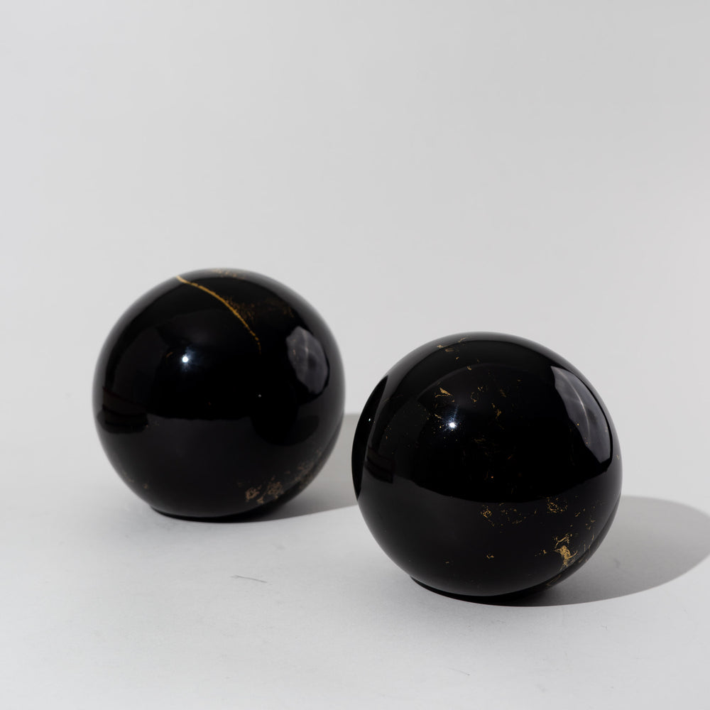 
                  
                    Pair of vintage black ceramic spheres with gold marbling, one large and one small, in the style of Sascha Brastoff
                  
                