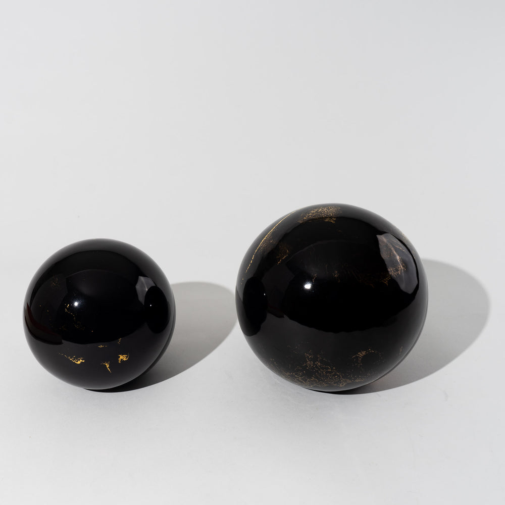 
                  
                    Pair of vintage black ceramic spheres with gold marbling, one large and one small, in the style of Sascha Brastoff
                  
                