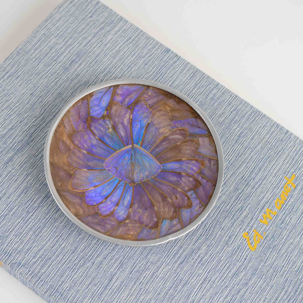 
                  
                    Vintage decorative plate made from iridescent purple and blue butterfly wings, mounted for wall display or table decor
                  
                