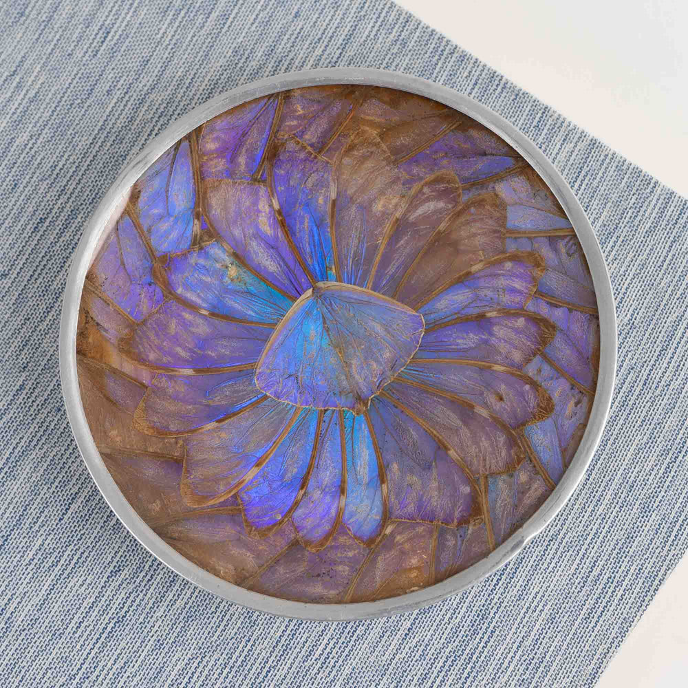 
                  
                    Vintage decorative plate made from iridescent purple and blue butterfly wings, mounted for wall display or table decor
                  
                