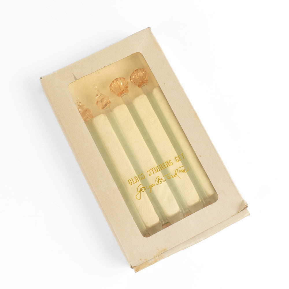 
                  
                    Set of four vintage glass drink stirrers with seashell designs in light pink and clear glass, designed by Georges Briard.
                  
                