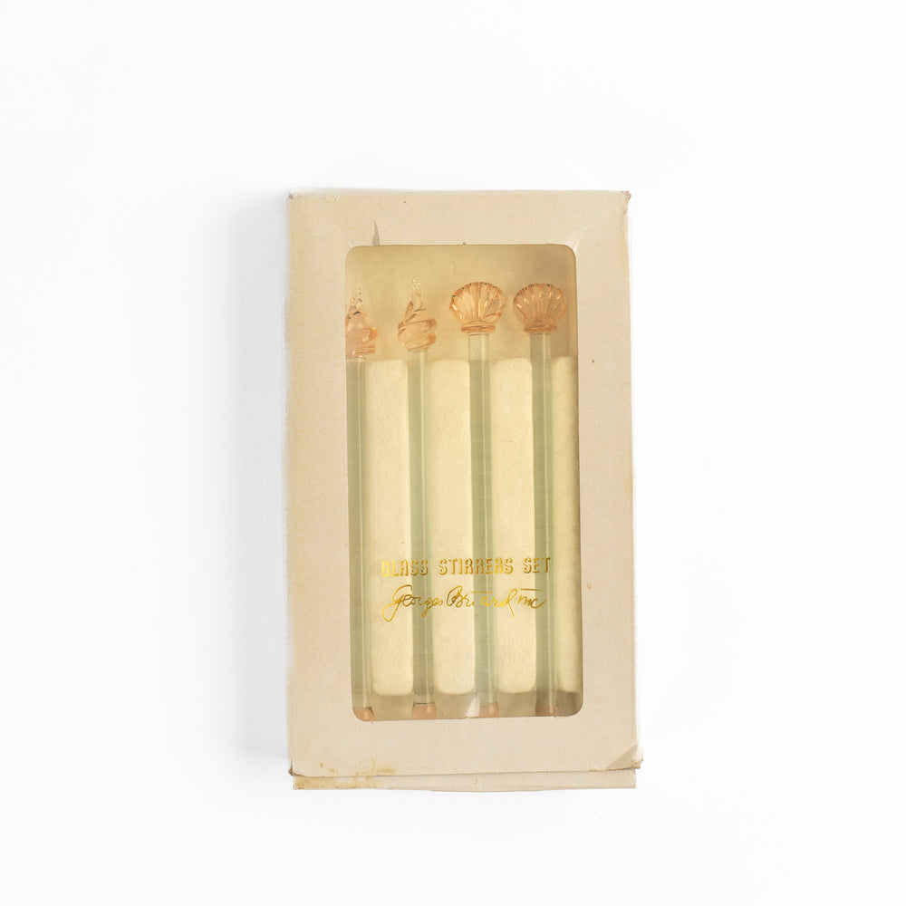 
                  
                    Set of four vintage glass drink stirrers with seashell designs in light pink and clear glass, designed by Georges Briard.
                  
                