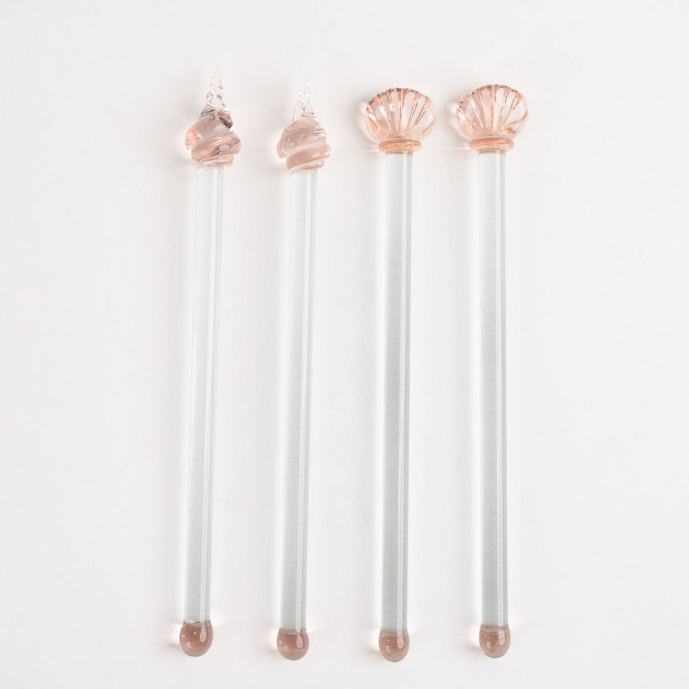 
                  
                    Set of four vintage glass drink stirrers with seashell designs in light pink and clear glass, designed by Georges Briard.
                  
                