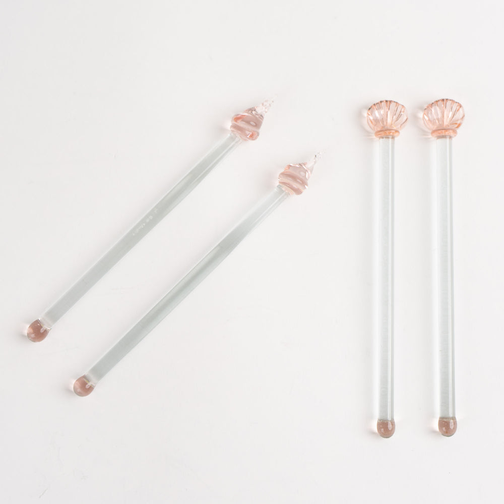 
                  
                    Set of four vintage glass drink stirrers with seashell designs in light pink and clear glass, designed by Georges Briard.
                  
                