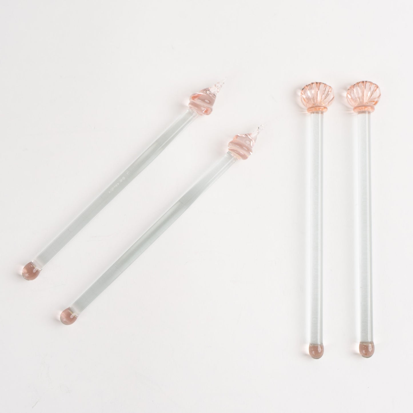 Set of four vintage glass drink stirrers with seashell designs in light pink and clear glass, designed by Georges Briard.