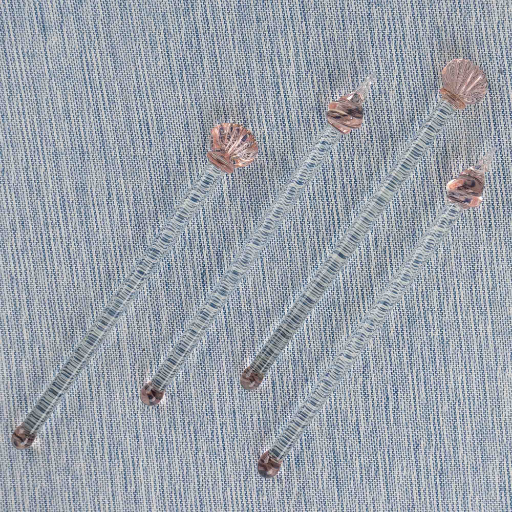 
                  
                    Set of four vintage glass drink stirrers with seashell designs in light pink and clear glass, designed by Georges Briard.
                  
                