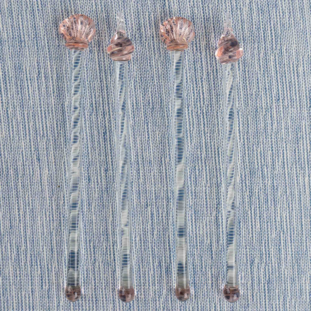
                  
                    Set of four vintage glass drink swizzle sticks with seashell designs in light pink and clear glass, designed by Georges Briard.
                  
                