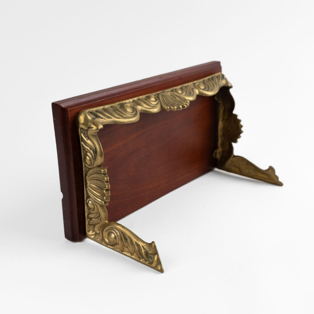 
                  
                    Vintage mid-century modern wall shelf with cherry wood surface, brass supports, and raised edge for displaying art

                  
                