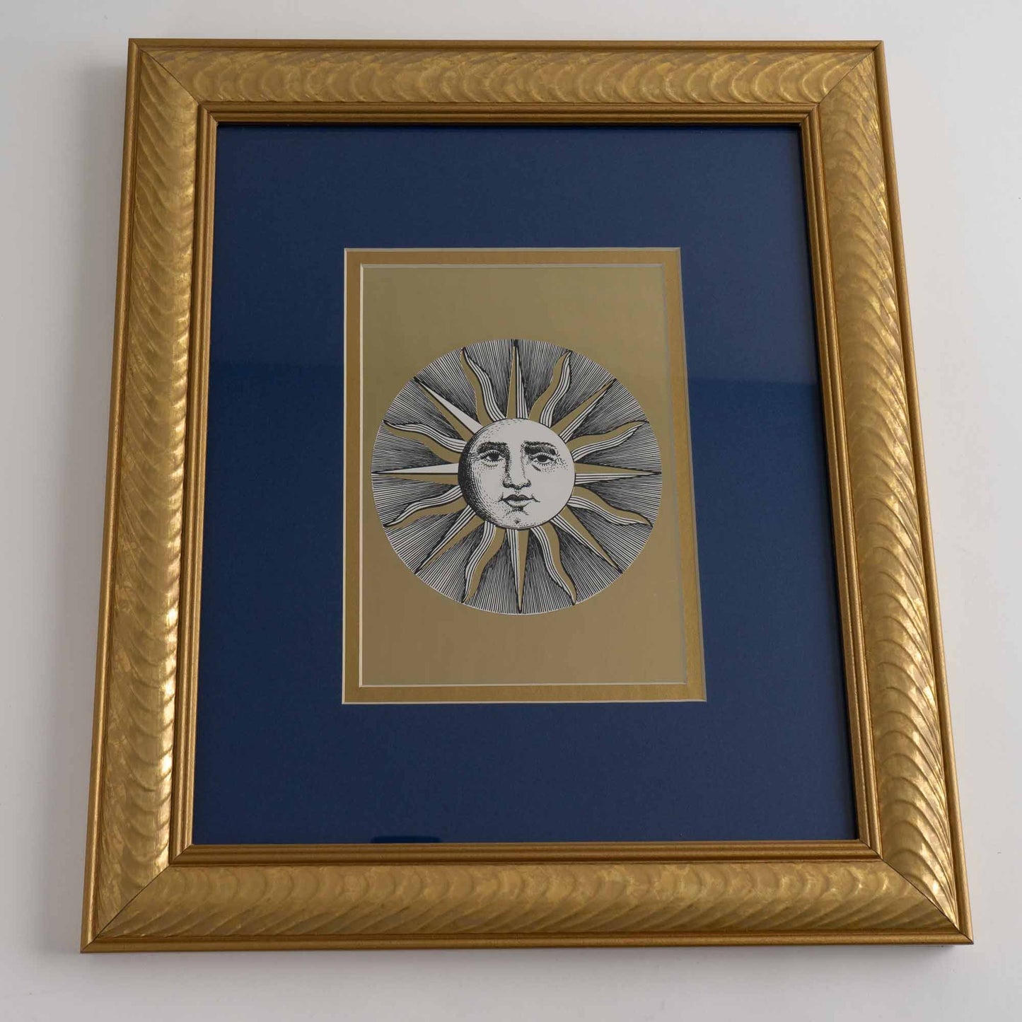 vintage Fornasetti Soli (sun) prints in gold frames with blue matting and metallic gold sun details