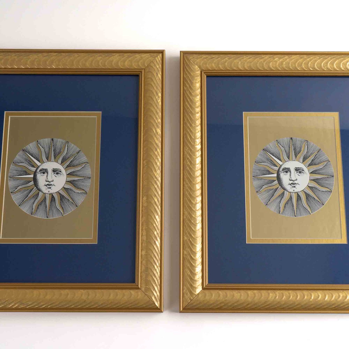 Pair of vintage Fornasetti Soli (sun) prints in gold frames with blue matting and metallic gold sun details